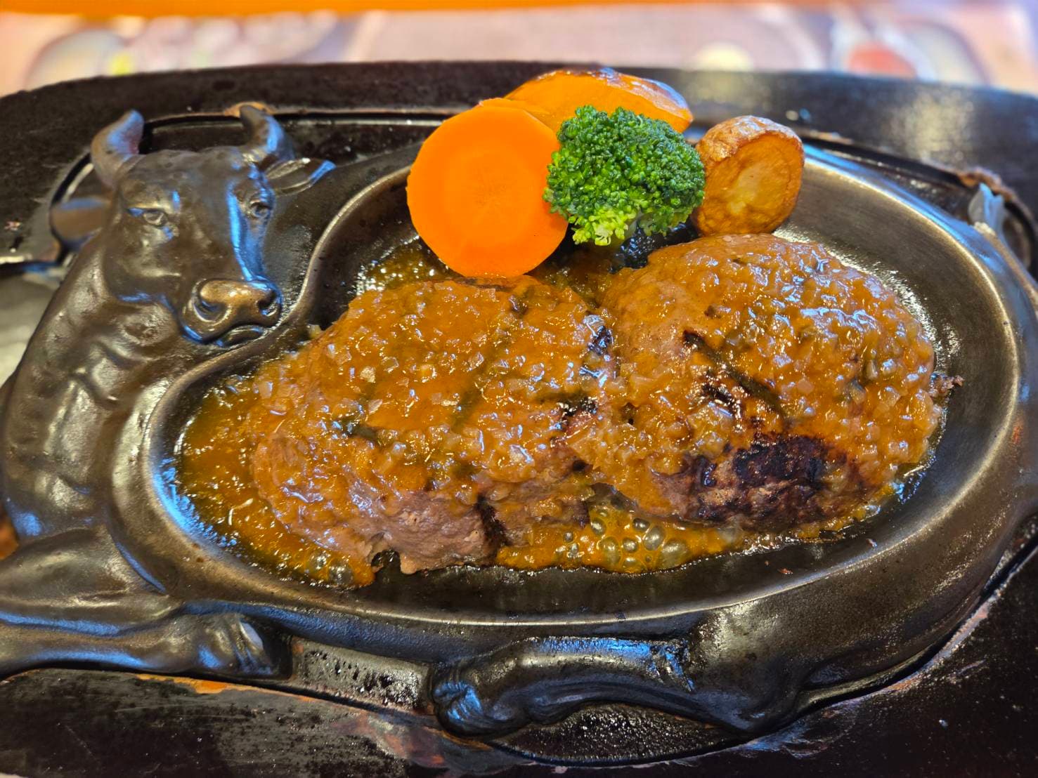 炭焼きハンバーグにソースをかけている様子