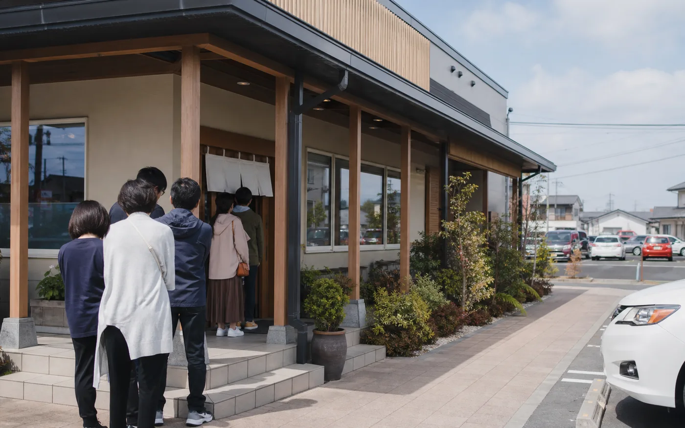 店先の行列と入口の位置を確認できる店舗外観写真